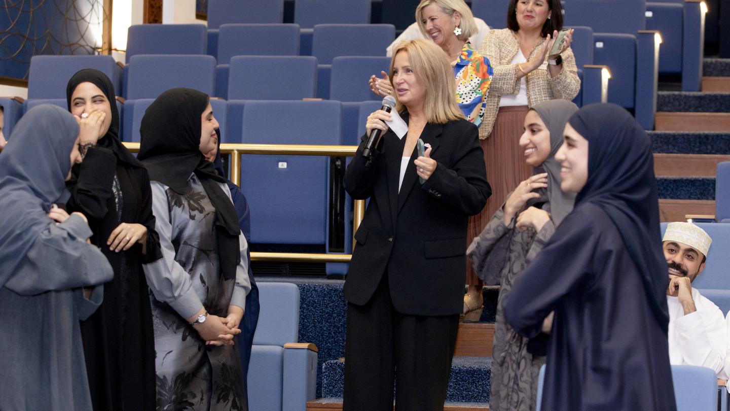 Board member speaks with Omani students