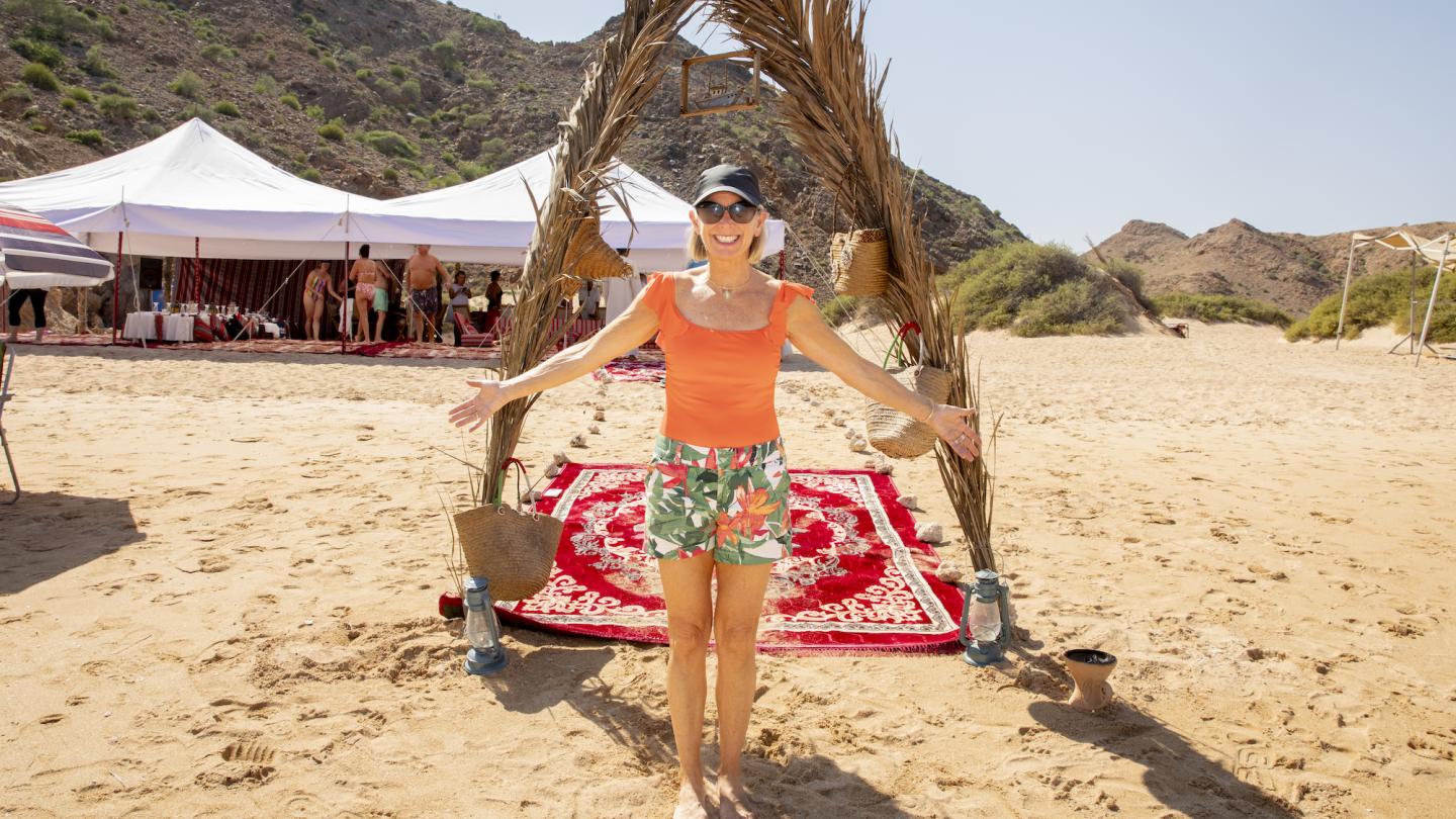 board member in front of a natural floral arch